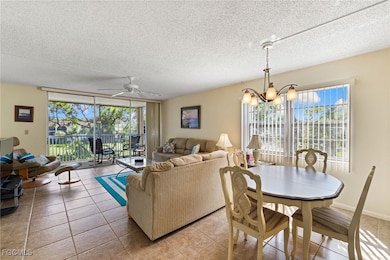 Dining space featuring tile patterned floors, a ceiling fan, a textured ceiling, a chandelier, and floor to ceiling windows