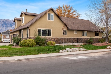 View of side of property with stucco siding, stone siding, a shingled roof, and a mountain view