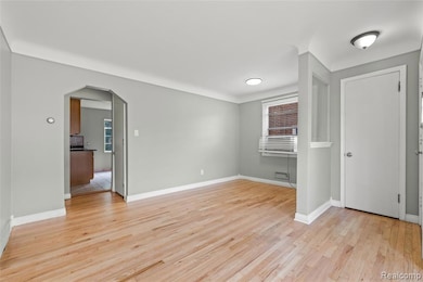 Unfurnished room featuring arched walkways and light wood-style floors