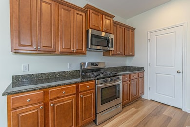 Kitchen featuring brown cabinetry, appliances with