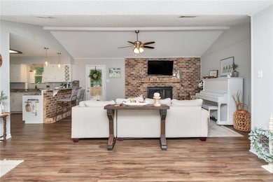 Living room with wood-type flooring, vaulted ceili