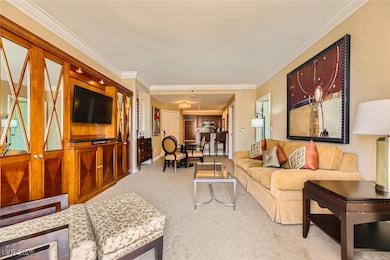 Living room featuring ornamental molding and carpe