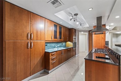 Kitchen with island range hood, dark stone counter