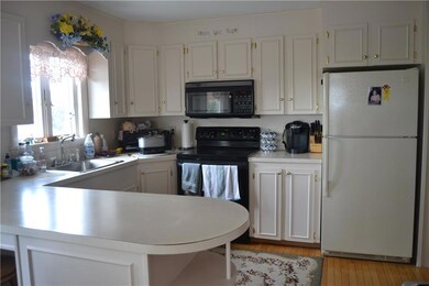 Kitchen with bar and hardwood floors.