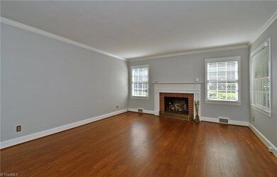 Living room with refinished hardwoods and gas logs.
