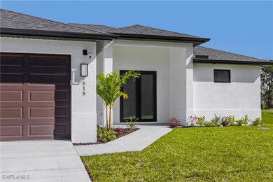 Property entrance with stucco siding, a lawn, a ga