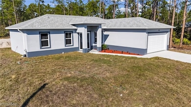 View of front of home with a garage and a front ya