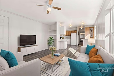 Living area with wood finished floors, ceiling fan, lofted ceiling, and crown molding