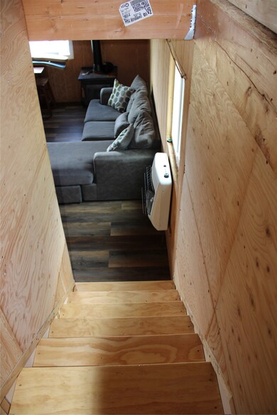 Stairs featuring wood-type flooring, wooden walls, and heating unit