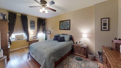 Bedroom with baseboards, ceiling fan, and wood finished floors