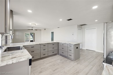 Kitchen offers light gray custom cabinetry with bu