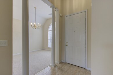 Carpeted entrance foyer featuring lofted ceiling, 