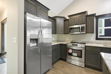 Kitchen features a center island, granite tops, stainless steel appliances, custom cabintery