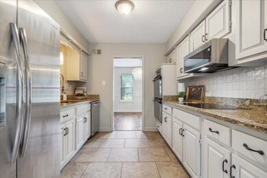 Kitchen featuring light tile flooring, light stone