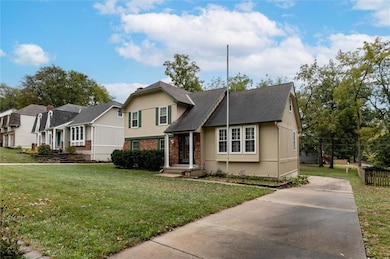 View of front of house featuring brick siding, stucco siding, and concrete driveway