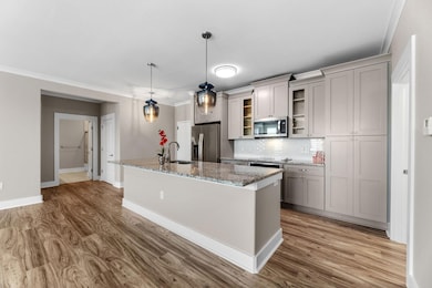 Kitchen featuring an island with sink, appliances 