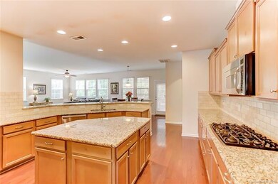 Granite Kitchen with Wood Flooring and Recessed Li