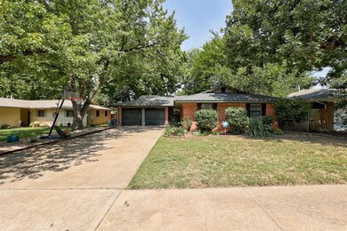 Ranch-style home featuring a front yard and a gara