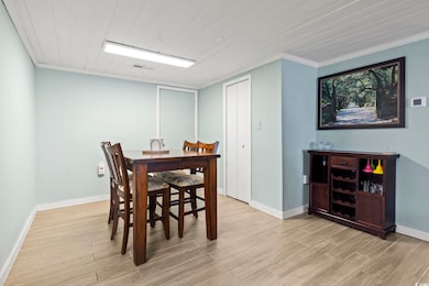 Dining space with crown molding, light wood-type f