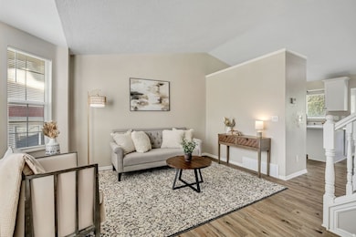 Living area with light wood-style floors and lofted ceiling