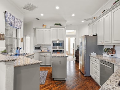 Kitchen with beautiful wood floors,  center island and window over cooktop