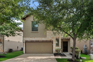 View of front facade with stone siding, a garage,