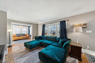 Living room with ornamental molding and wood-type flooring