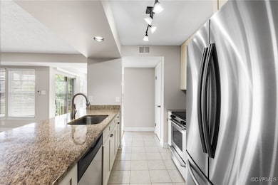 Kitchen with stainless steel appliances, a sink, r