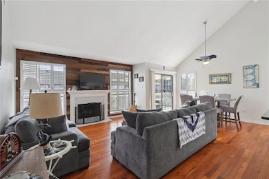Large living space with wood flooring and a vaulted ceiling.