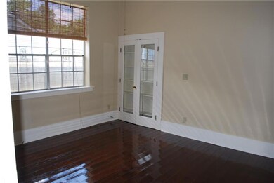 Large light filled bedroom has high ceilings, wood