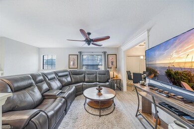 Living area with a ceiling fan and light wood-styl