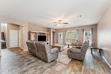 Large family room with tile flooring and ceiling f