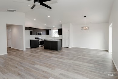 Kitchen with open floor plan, stainless steel appliances, light countertops, light wood finished floors, and recessed lighting