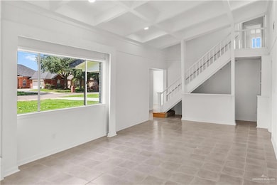 Unfurnished living room with beam ceiling, coffered ceiling, stairs, and recessed lighting