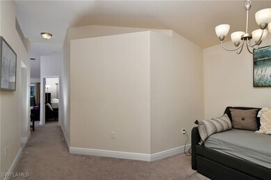 Living area with an inviting chandelier, carpet, and lofted ceiling