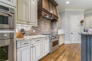 Custom cabinets along with the custom vent hood make an impressive picture when entering the home.  A large walk-in pantry provides plenty of space for storage.