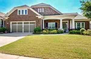 Craftsman-style home with a front yard, an attached garage, and concrete driveway