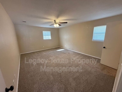 Carpeted empty room featuring baseboards and ceiling fan