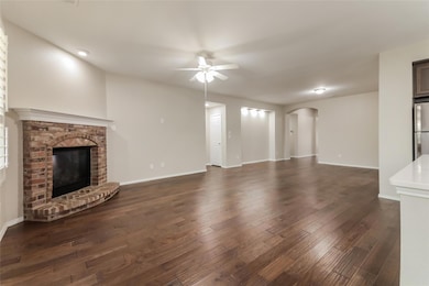 Unfurnished living room with ceiling fan, a brick 
