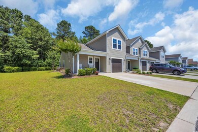 Traditional home with an attached garage, driveway, and a front lawn