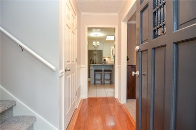 Hallway featuring stairway, a textured ceiling, li