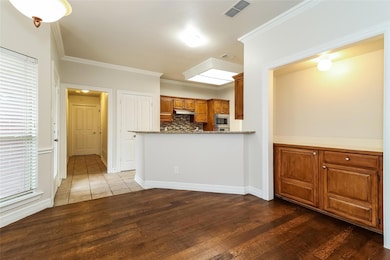 Kitchen with ornamental molding, light stone count