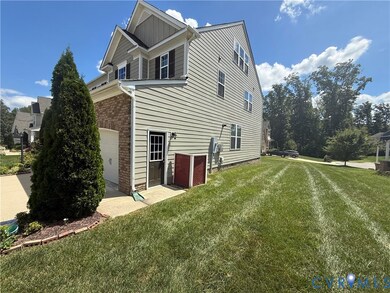 View of home's exterior with a garage, brick siding, and a lawn