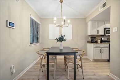 Dining area with light wood-type flooring, crown m