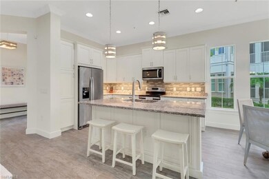 Kitchen with appliances with stainless steel finishes, a sink, light wood finished floors, tasteful backsplash, and white cabinets