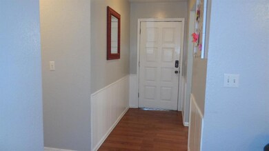 Entry. To the left is a hallway to bedrooms. Door 
