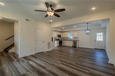Unfurnished living room featuring ceiling fan with