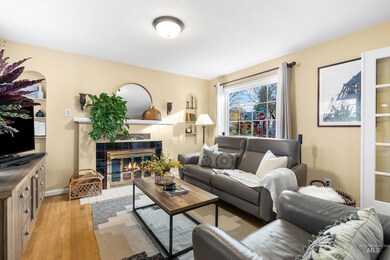 Living room featuring light wood-type flooring and a tile fireplace