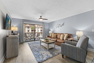 Living room featuring a ceiling fan, wood finished floors, and a textured ceiling