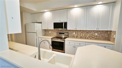Kitchen with light countertops, a sink, tasteful b